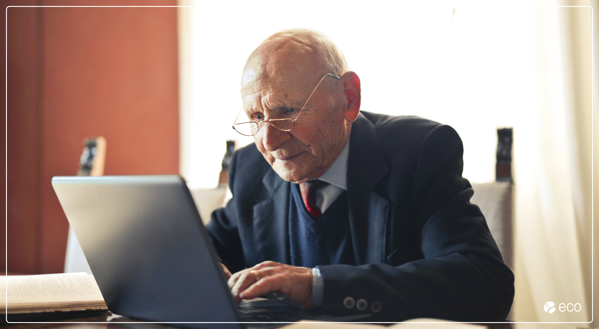 Elder man writing on a laptop